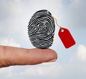 Selling private information and social media personal data market concept as a finger holding a fingerprint with a price tag as an internet business with 3D illustration elements.